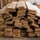 Pile de planches de bois disposées sur le sol dans un atelier.